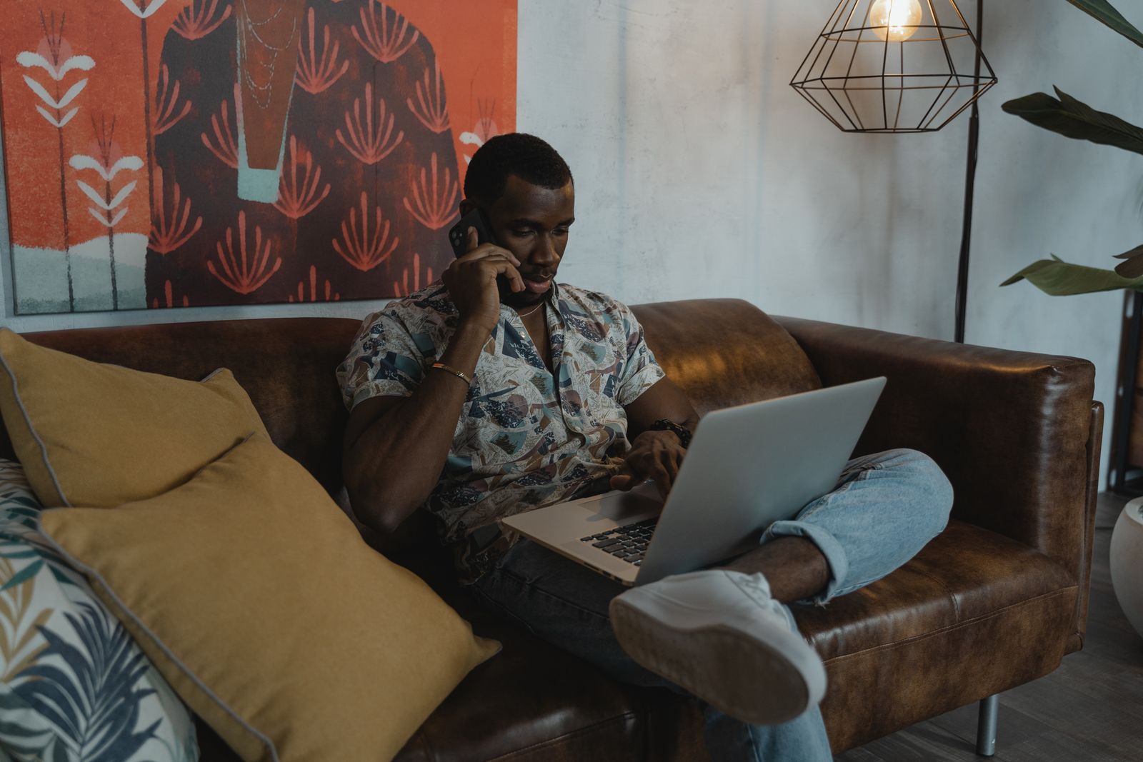Man calling his insurance company while reviewing documents on a laptop